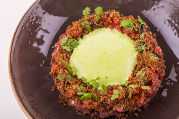 The Tartar with ajika, beef and leek, is served with tomatoes 