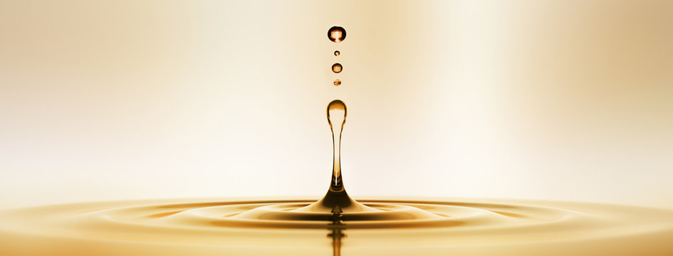 Goldener Wassertropfen vor hellem Hintergrund