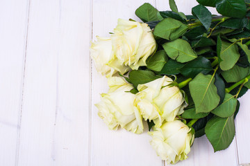 Bouquet of roses on white wooden table
