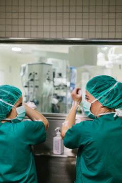 Couple of Surgeons Washing Hands Before Operating