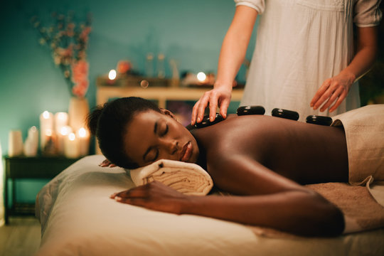 Woman receiving hot stone massage at luxury spa