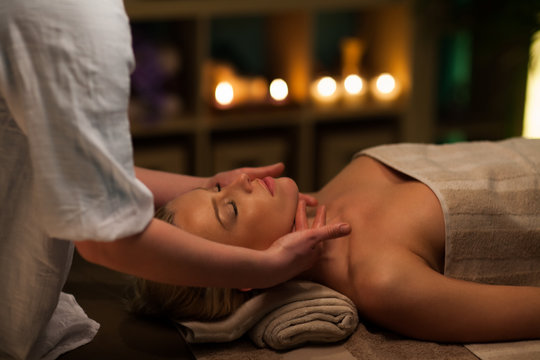 Woman receiving face massage at spa