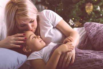 happy family mother and child daughter on Christmas morning in bed