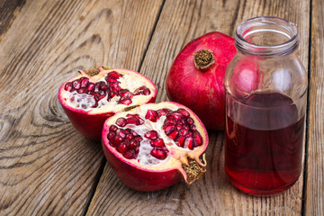 Whole and half-cut pomegranate on wooden table