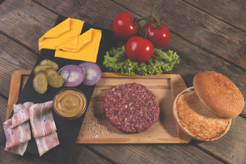 homemade cheeseburger fresh ingredients cheese, bun, salted cucumber, beef patties,bacon