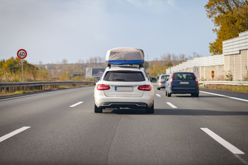 Fototapeta na wymiar white car with porter drives on a german motorway