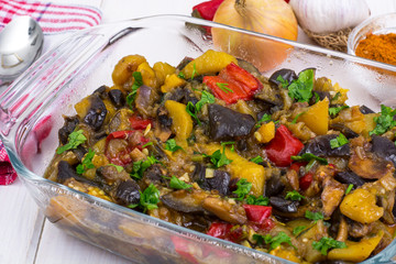 Vegetable saute with eggplant on white wooden background