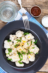 Black plate with boiled vegetarian vegetable dumplings