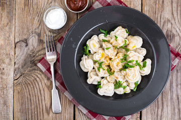 Black plate with boiled vegetarian vegetable dumplings
