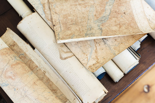 Looking down on pieces of antique maps and scrolls.