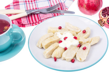 Dumplings from cottage cheese with yoghurt and pomegranate seeds