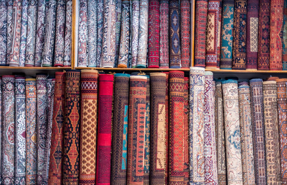 A roll of carpets stacked up against a wall.