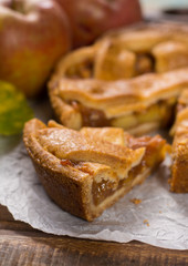 Traditional homemade apple pie with nuts and cinnamon close up and fresh ripe Golden Reinette apples