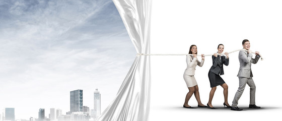 Young businesspeople working in collaboration and pulling white advertisement banner