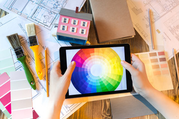 Flatlay interior designer with pad and colour circle, plans and art tools