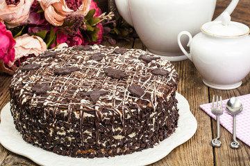 Homemade cake with chocolate icing on wooden table