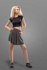 Fototapeta premium blonde female model dressed in short gray skirt isolated