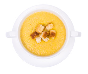 Vegetable soup cream with crackers on white background, top view