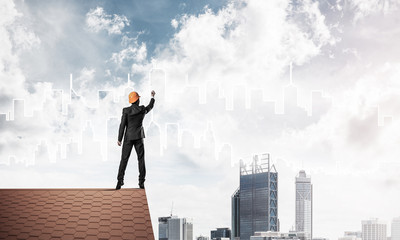 Man architect draw silhouette of modern city on blue sky. Mixed 