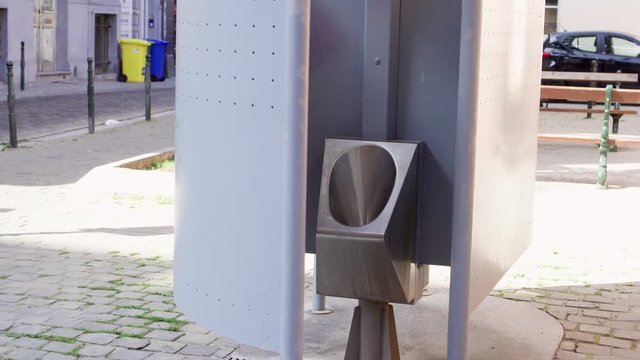 Outdoor public urinal at Brussels, Belgium. Empty pissoir standing on street of Europe.