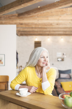 Senior woman in her living room with a cup of tea.
