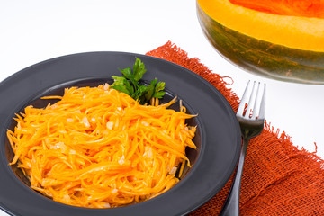 Salad of pumpkin, onion and vegetable oil in black plate