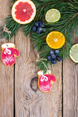 Homemade gingerbread cookies glazed and christmas tree branches with fruits.