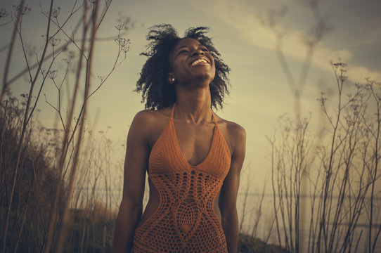 African American Woman Smiling In Swimsuit On Beach