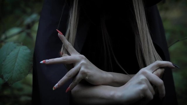 Woman in the forst scares with her sharp nails.
