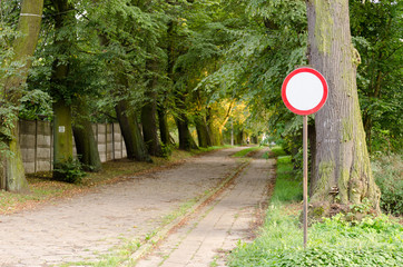 Droga w parku ze znakiem zakaz wjazdu. - obrazy, fototapety, plakaty