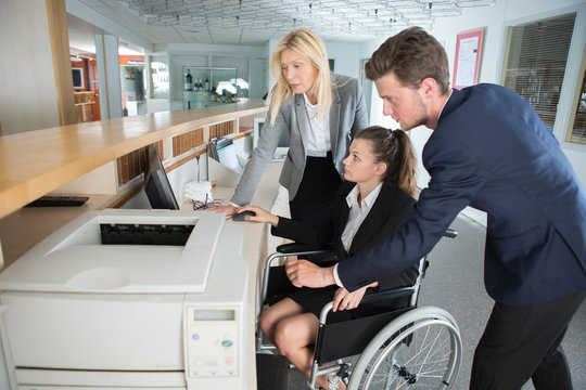 disabled businesswoman in wheelchair and her colleague in the office