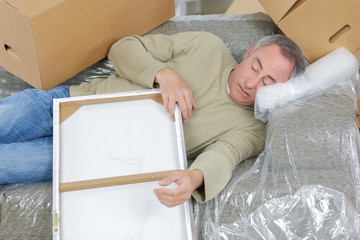 man sleeping in between boxes