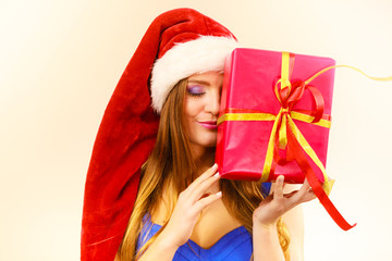 Woman in santa claus hat holds gift box. Christmas time