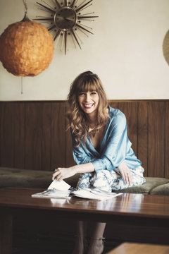 A beautiful woman flipping through a magazine laughing