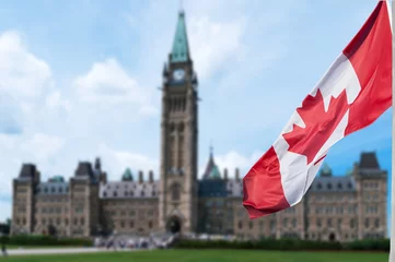 Fotobehang Canadese vlag die met de heuvel van Parlementsgebouwen op de achtergrond zwaait Ottawa, Ontario, Canada © DD Images