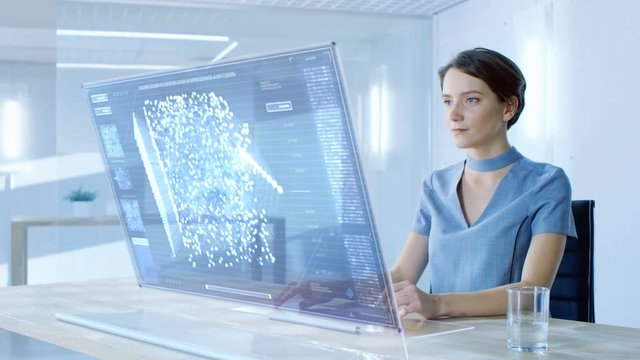 In the Near Future Stylish Woman Working on Her Computer with Transparent Display. Display Shows Graphic Projection of Neural Network, Artificial Intelligence Simulation. 