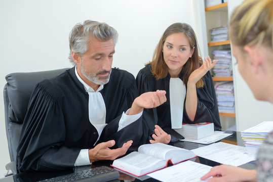 robed lawyer in meeting with client