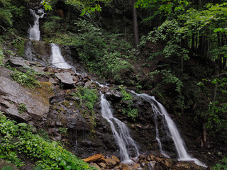 Fototapeta na wymiar Waterfall at the carpatian mountains green forest