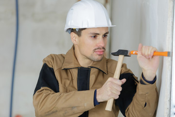 young builder holding chisel and hammer