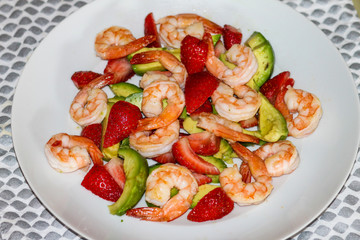 Salad with strawberry, shrimps, and avocado.