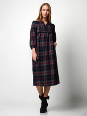 Young beautiful woman posing in new fashion gray dress in a cage full body