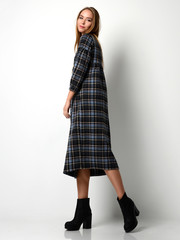 Young beautiful woman posing in new fashion gray dress in a cage full body