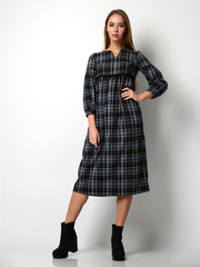 Young beautiful woman posing in new fashion gray dress in a cage full body