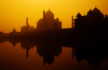 Sunset silhouette of a grand Taj Mahal.