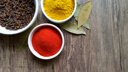 Condiments in white glass bowl on wooden background
