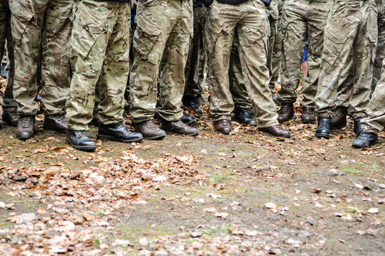 Soldiers in camo trousers and boots at the start of a long distance, cross country run.