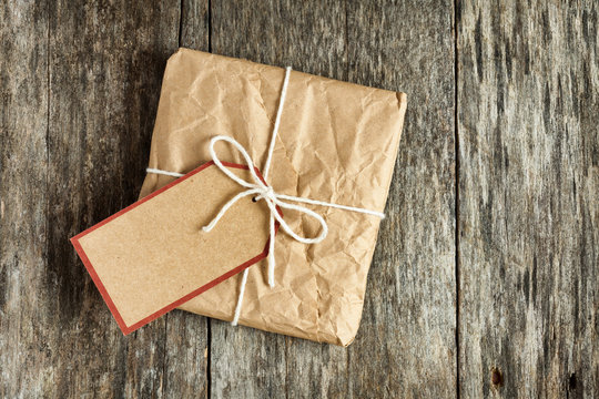 Package with a blank tag and wrapped in wrinkled brown paper lyi