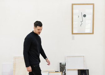 Man taking care of frames in an exhibition