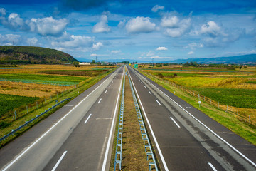 Modern empty highway going through fields
