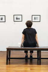 People looking at frames in an exhibition